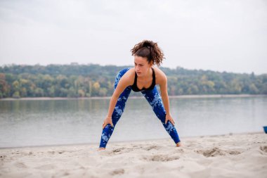 Yorgun sporcu kum üzerinde antrenman yaptıktan sonra geriniyor, yaz gününün tadını çıkarıyor..