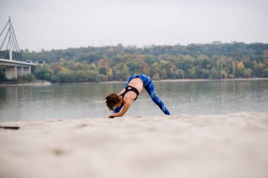 Genç ve güzel bir kadın kumların üzerinde uzanıyor..