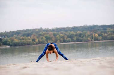 Sahilde uzanan genç bir kadının ön görüntüsü, tam uzunlukta..