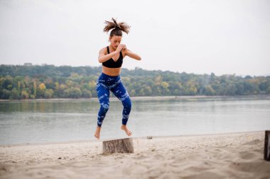 Beyaz kadın plaja atlıyor, tahta kütük kullanıyor..
