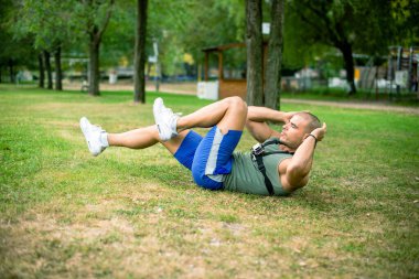 Parkta mekik egzersizi yapan sporcu, tam boy.