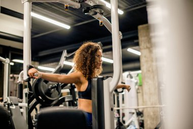 Çekici kadın spor salonunda silah egzersizi yapıyor.