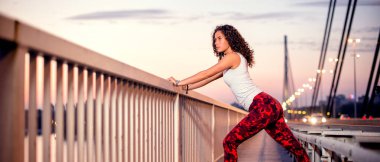 Köprüde gerinen genç sporcu, yan görüş.