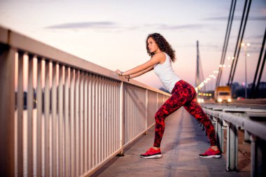 Köprüdeki eğitimden sonra esneme hareketleri yapan genç bir kadın..