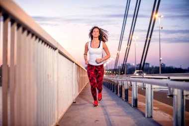 Köprüde koşan beyaz bir kadın var..