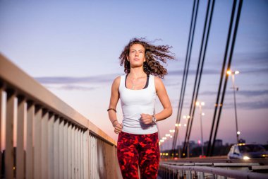 Köprüde koşan beyaz bir kadın var..