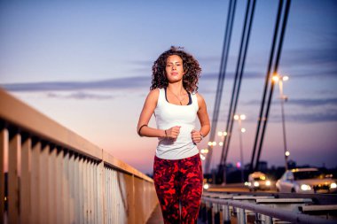 Köprüde koşan beyaz bir kadın var..