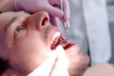 Bir hastanın diş dişçi ofisinde inceleyerek diş hekimi.