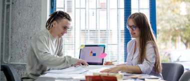 Genç adam ve kadın büroda.