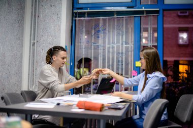 İki meslektaş gece geç saatlerde iş yerinde pizza yiyorlar.