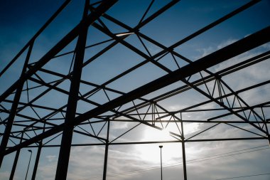 Mavi gökyüzünün önünde, gölgelerde çelik inşaatı