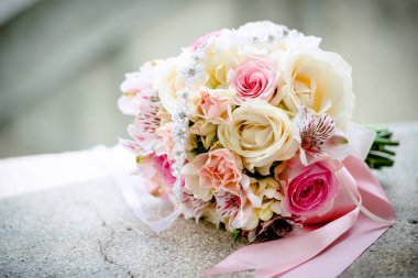 Düğünde masada kurdeleli pembe ve beyaz güller.