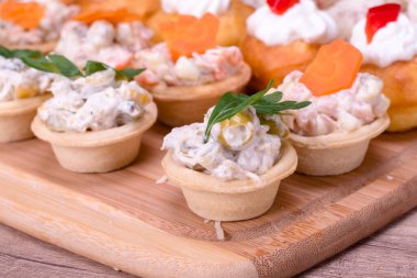 Ahşap tabakta güzel dekore edilmiş yemek servisi.