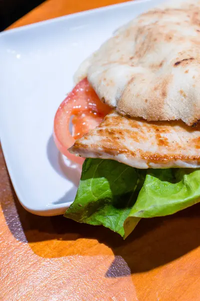 stock image Cropped image of chicken burger with lettuce and tomato.