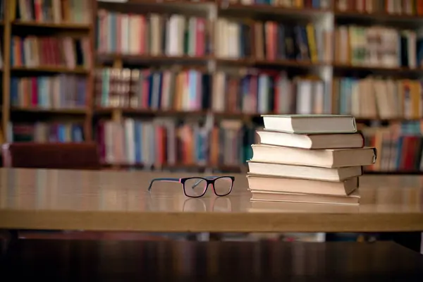 Bücher Und Brillen Auf Holzschreibtisch Der Bibliothek Bücherregale Hintergrund — Stockfoto