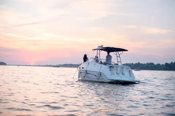 Günbatımında genç insanlarla tekne gezintisi.