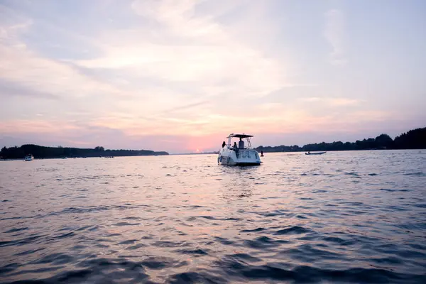 Günbatımında genç insanlarla tekne gezintisi.