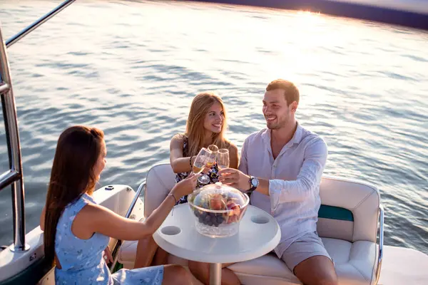 Dostlar gün batımında bir teknede selamlaşıyorlar