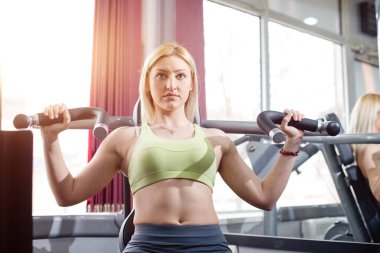 Spor salonunda kol egzersizi, sarışın genç kız.