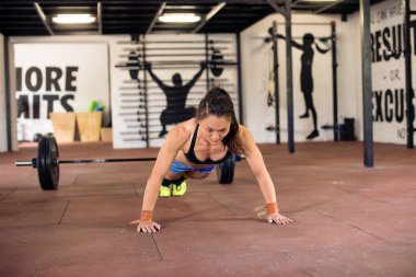 Çekici Asyalı kız spor salonunda şınav çekiyor.