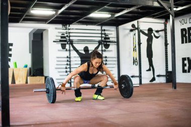 Çekici kız spor salonunda ağırlık kaldırıyor.