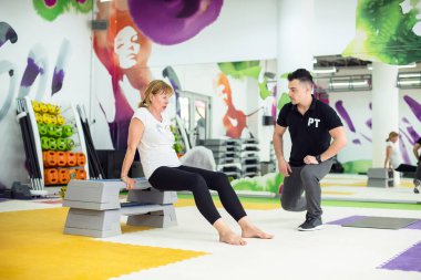 Spor salonunda kişisel antrenörle egzersiz yapmak.