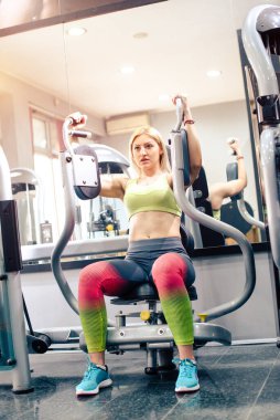 Güzel sarışın spor salonunda egzersiz yapıyor.