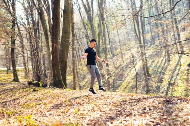 Parkta ip atlayan yakışıklı kaslı adam.