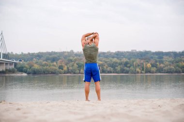 Sahilde gerinen bir adamın arka görüntüsü..