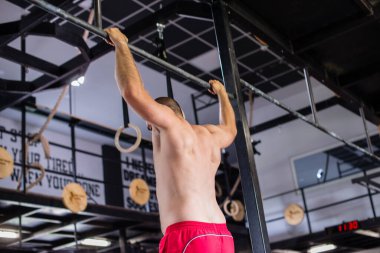 Adam spor salonunda şınav çekiyor.