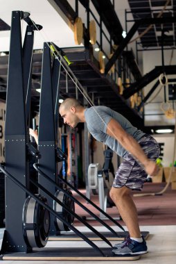 Adam spor salonunda spor makinesinde egzersiz yapıyor.