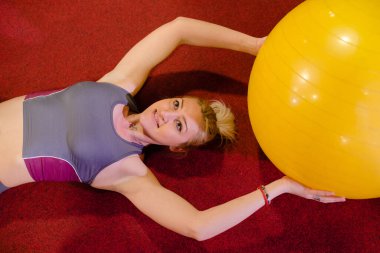 Pilates sarı topla pratik yapar.