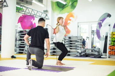 Kıdemli bayan spor yapıyor. Formda bir antrenörle.