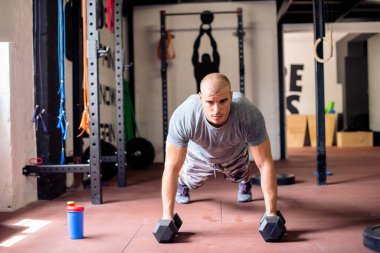 Spor salonunda şınav çeken seksi adam.