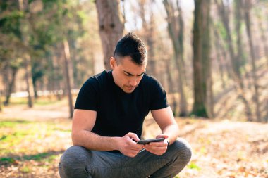 Genç yakışıklı koşucu, telefon.