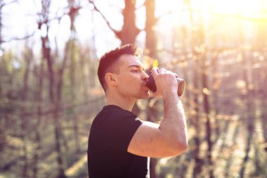 Genç adam sabah koşusundan sonra mola veriyor, park ediyor.