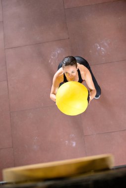 Genç kadın antrenman için ilaç topu atıyor.