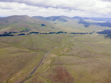 Dağların panoramik fotoğrafı ve bir çayır. Doğada huzurlu bir yer.