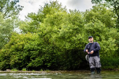Erkekler yazın nehir kenarında balık tutmayı severler.