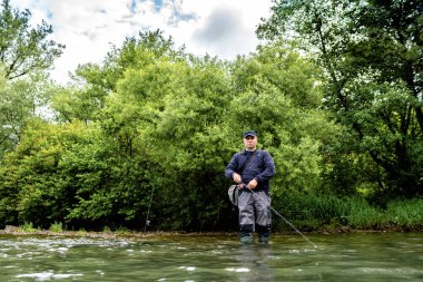 Erkekler yazın nehir kenarında balık tutmayı severler.