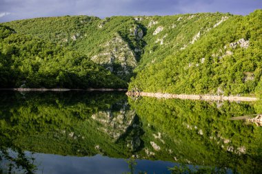Doğada güzel, huzurlu bir yer. Dağlar, ağaçlar ve tatlı su.
