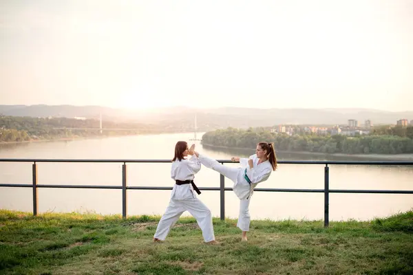 Two karate woman fighting on outdoor.