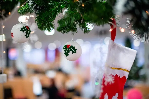 Noel süslemesinin kapanışı: kırmızı Noel çorabı, Noel süsleri ve Noel ağacındaki ışıklar..