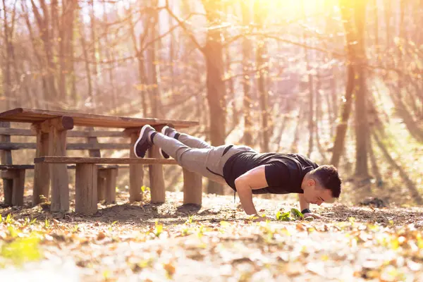 Fitness genç adam şınav ya da kalas yapıyor, doğada