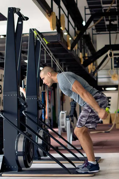 Adam spor salonunda spor makinesinde egzersiz yapıyor.