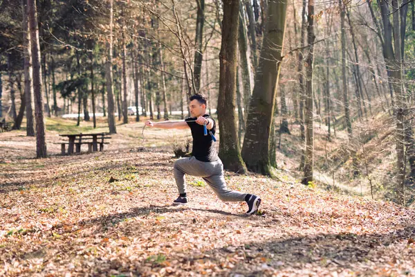 Adam doğada iple eğitiyor, park ediyor.