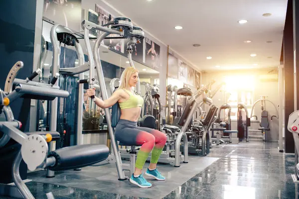 Attractive blonde at gym, having training alone