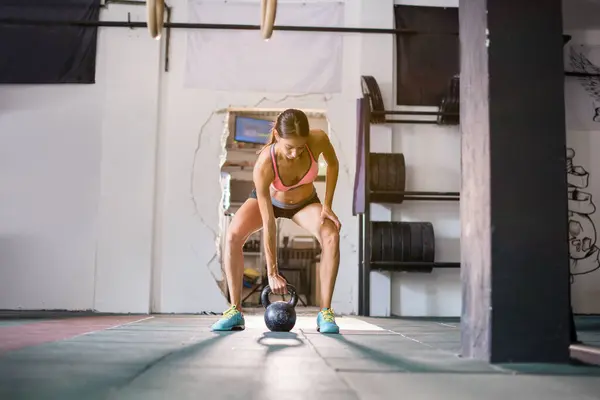 Strong young woman working out in gym