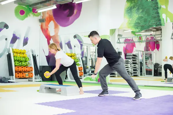 Kıdemli kadın ağırlık antrenmanı yapıyor.