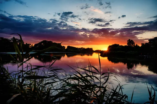 Göl suyunda bulutlu güzel günbatımının yansıması. Yaz zamanı.